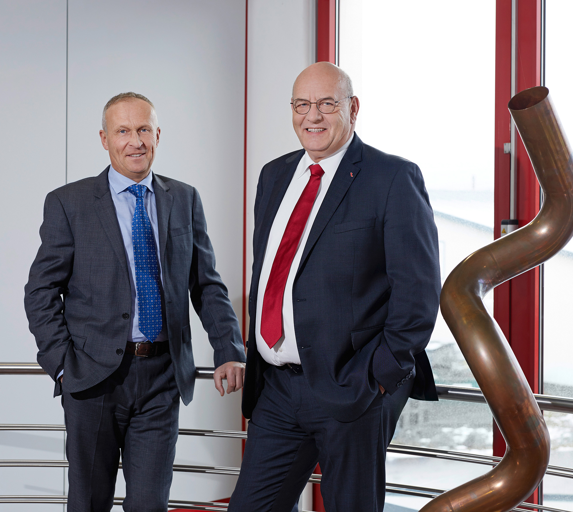 Geschäftsführer von transfluid neben gebogenem Rohrbauteil.