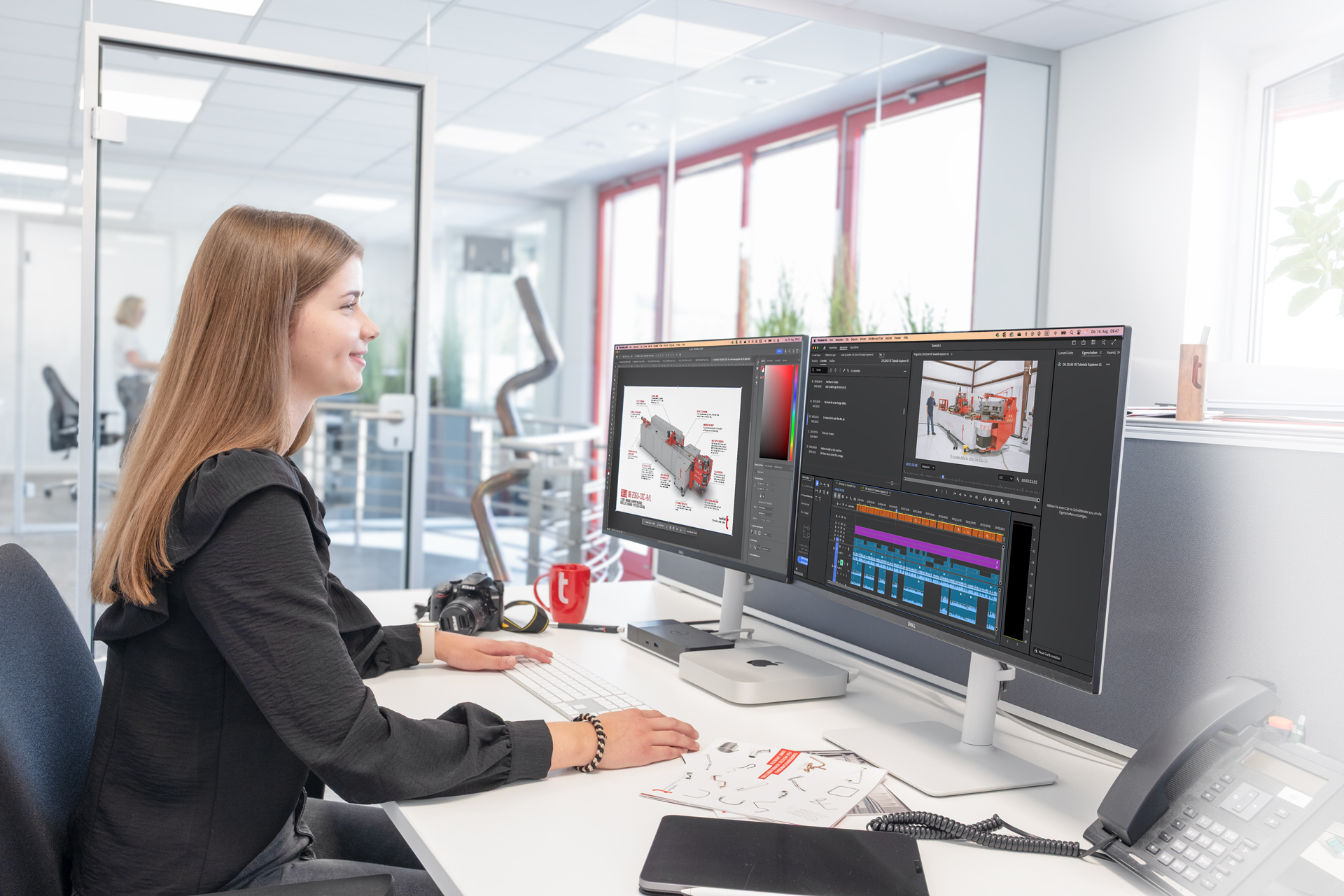 Mediengestalterin bearbeitet Grafik und Video an zwei Monitoren im modernen Büroarbeitsplatz.