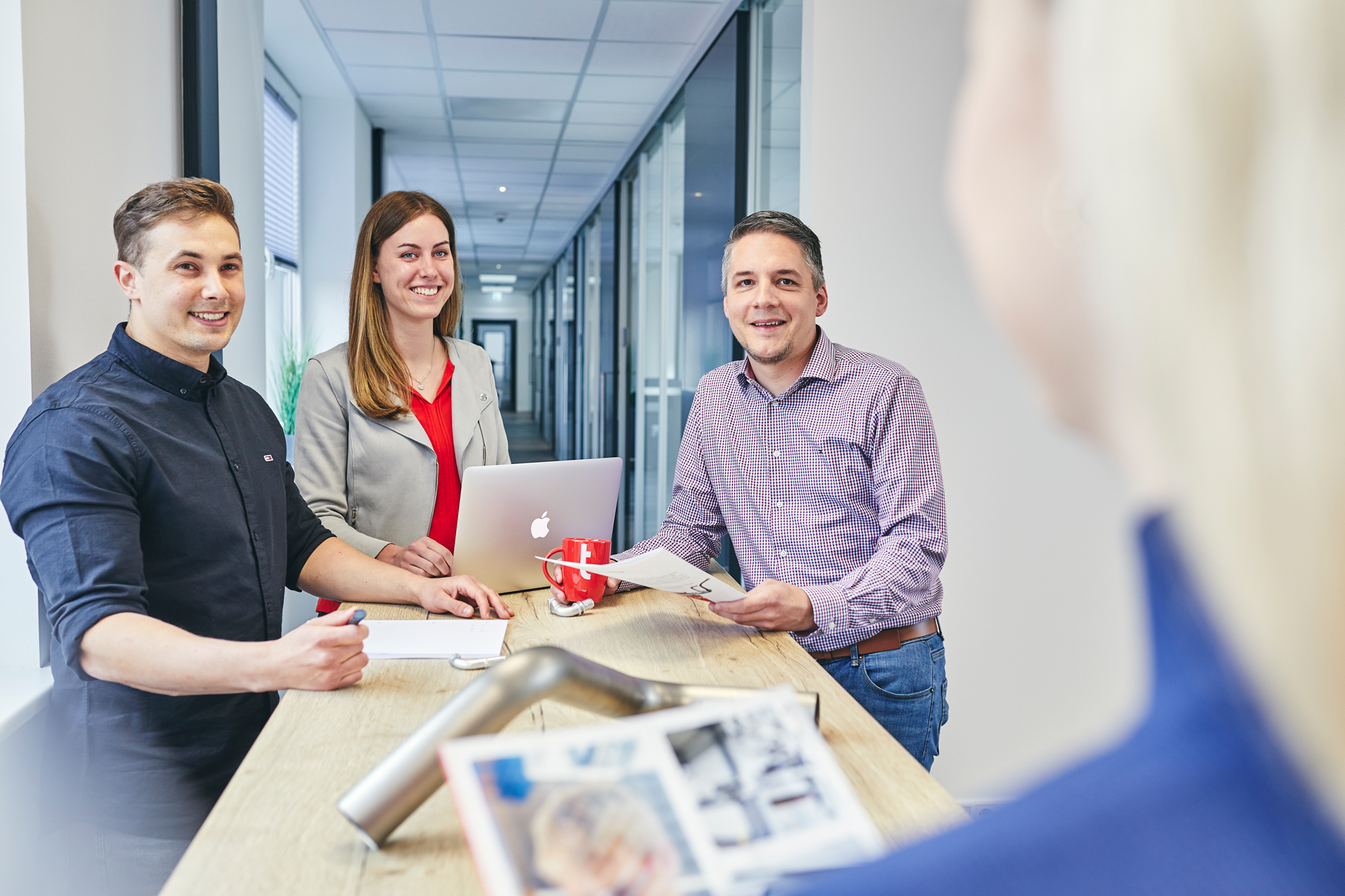 Vertriebsteam von transfluid im Meeting mit Laptop und Bauteil.
