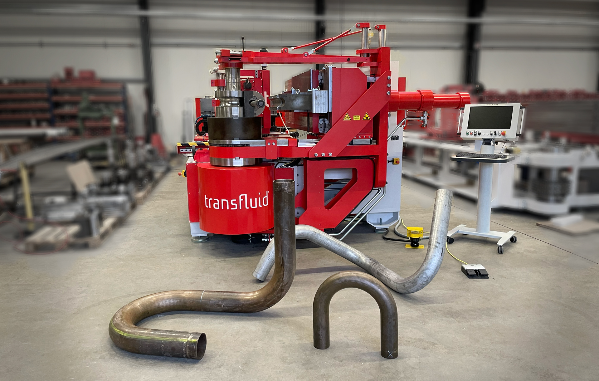 Rohrbiegemaschine mit gebogenen Metallrohren in einer industriellen Fertigungshalle.