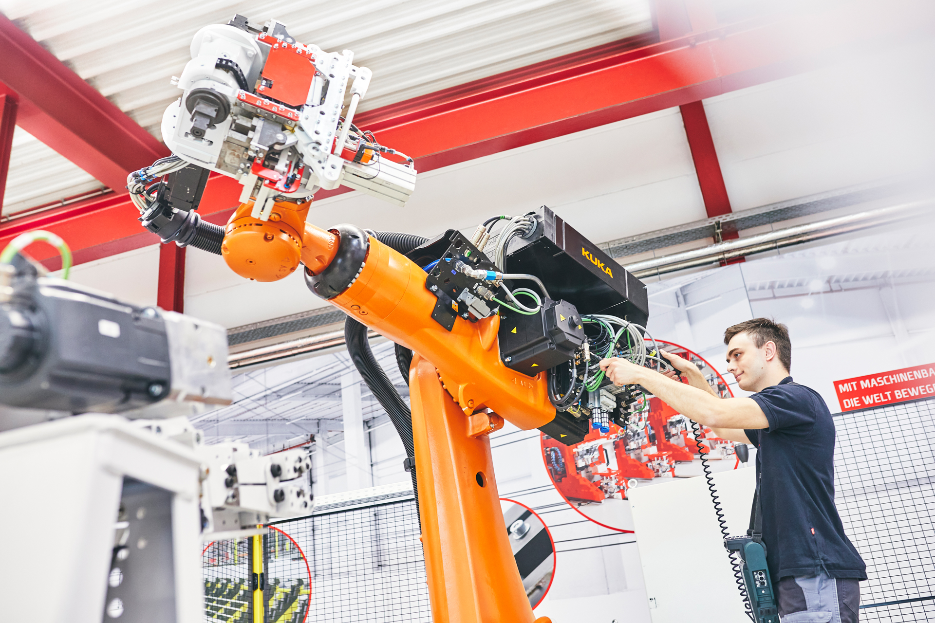 Techniker arbeitet an KUKA Industrieroboter in automatisierter Fertigungsanlage