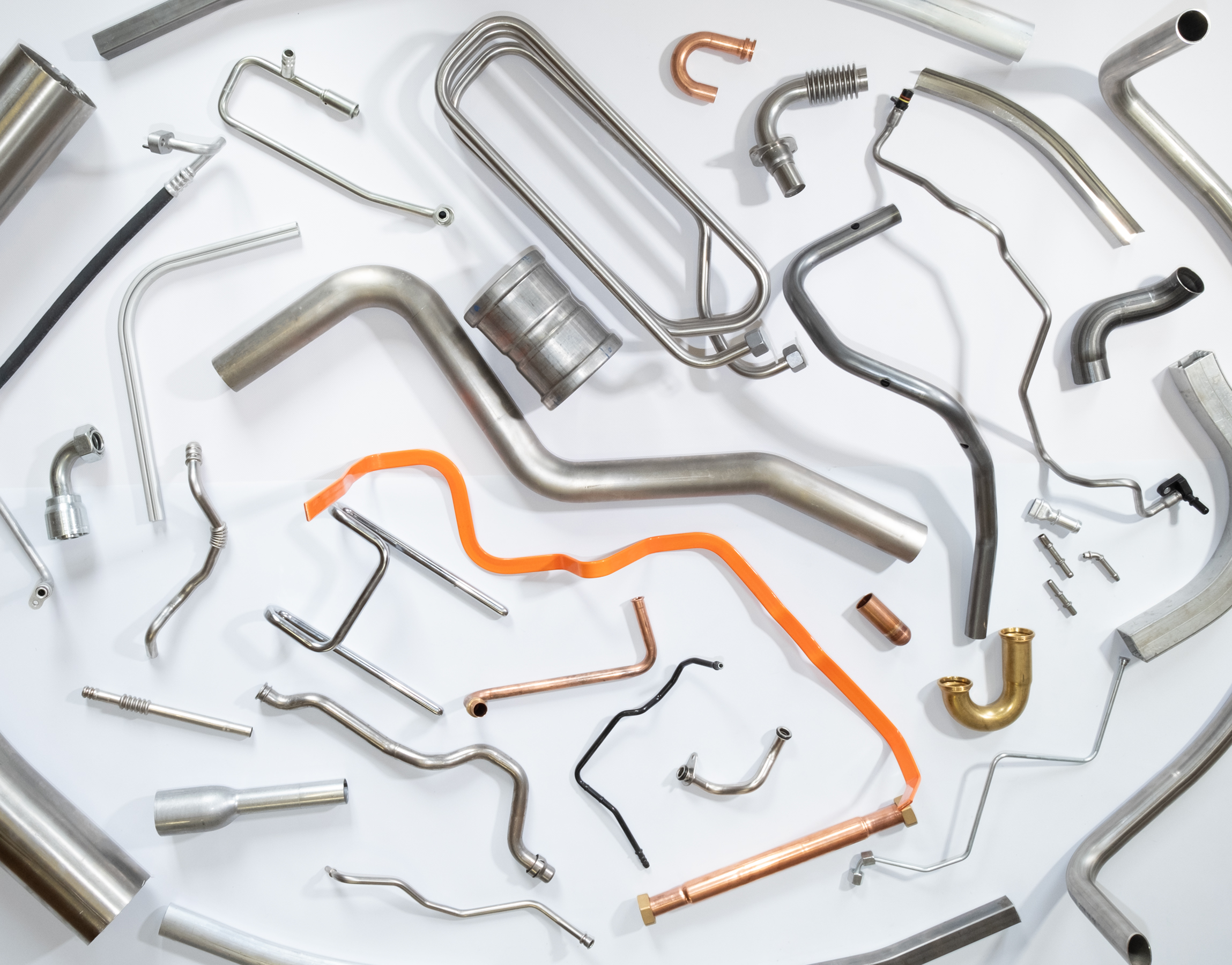 Vielfalt gebogener Metallrohre und Rohrbiegeteile in unterschiedlichen Formen und Materialien.