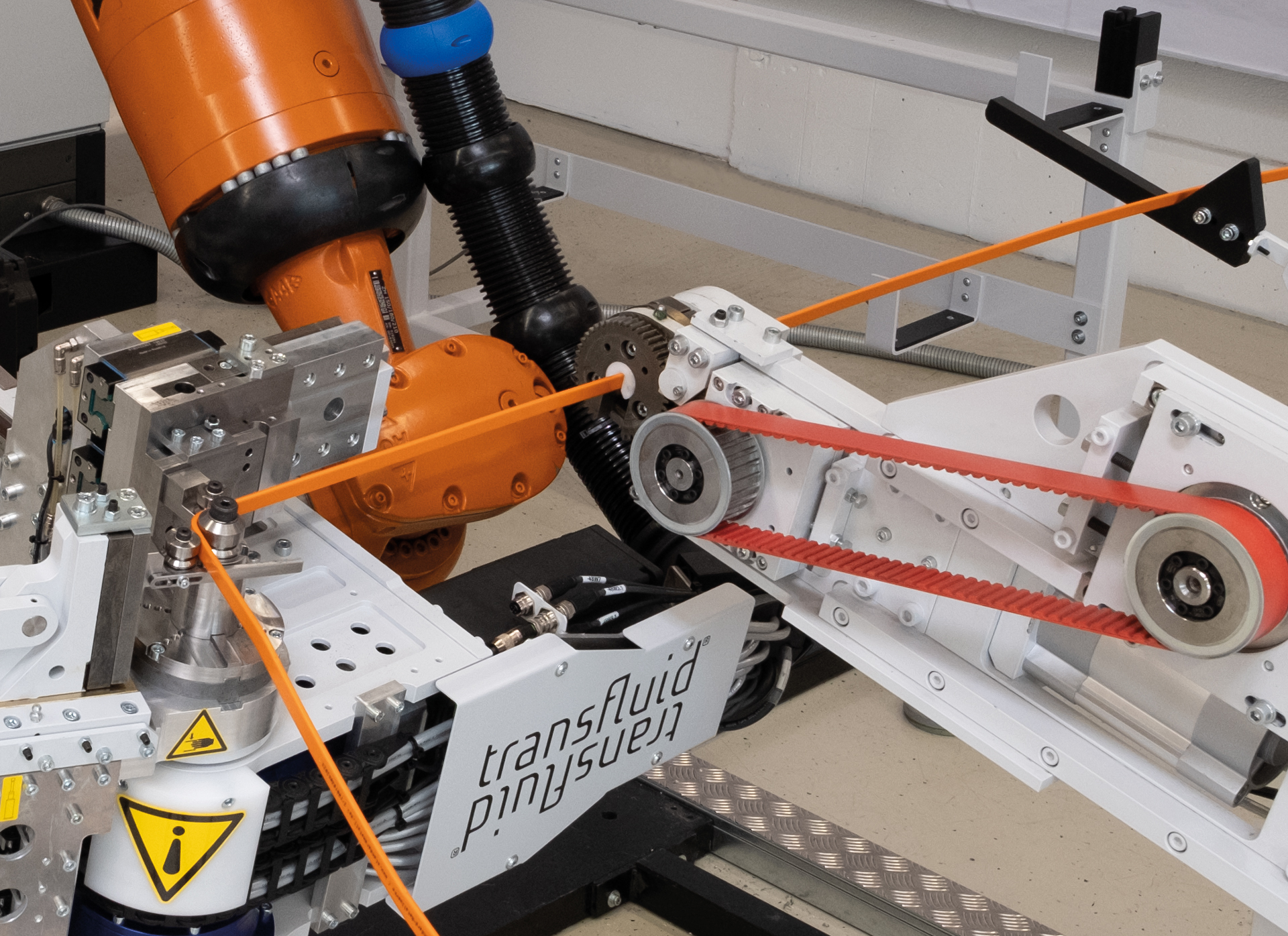 Industrieroboter biegt Stromschiene in automatisierter Busbar-Biegeanlage mit Rollenführung.