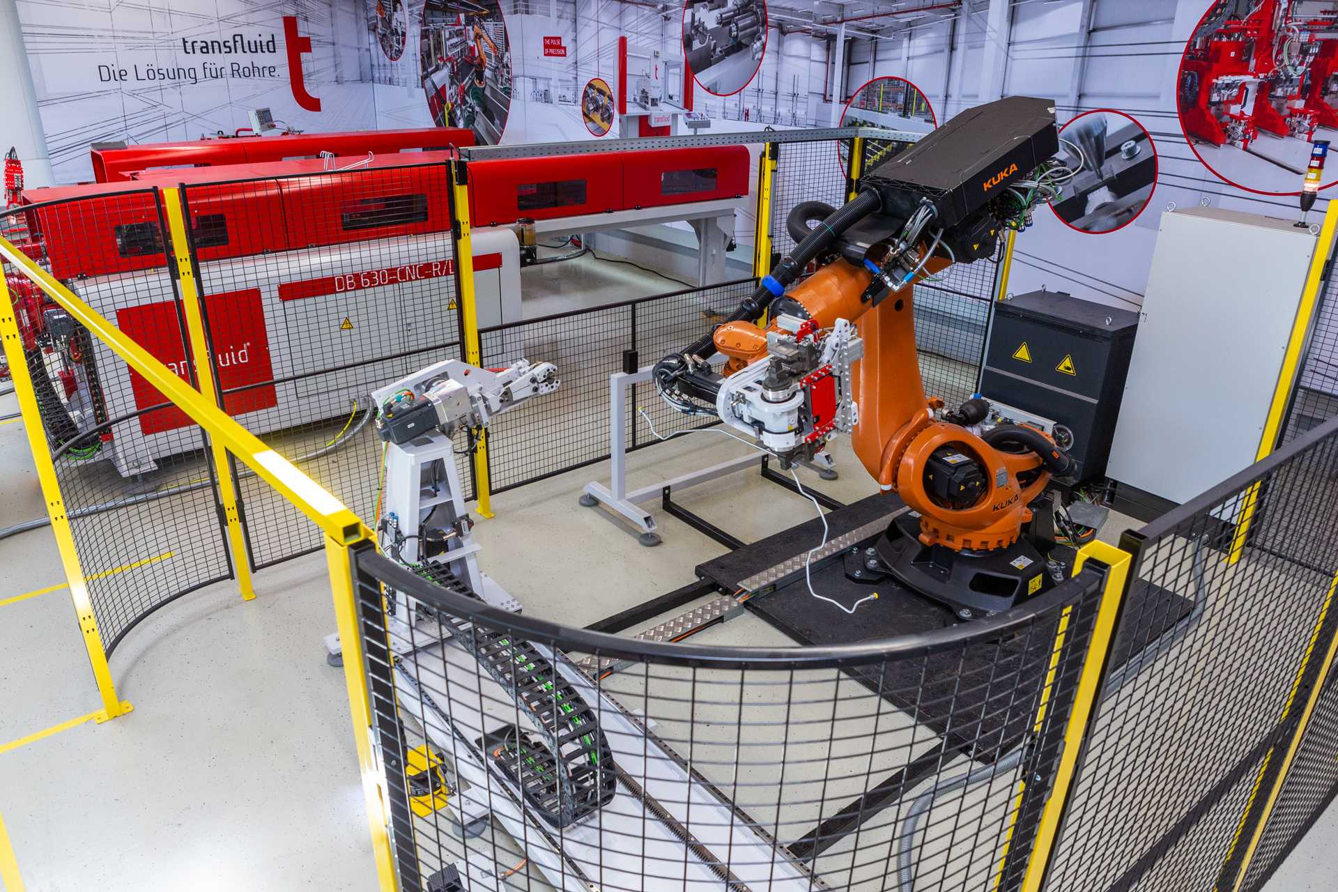 Automatisierte Rohrbiegezelle mit Industrieroboter und CNC-Biegemaschine in moderner Produktionsumgebung.