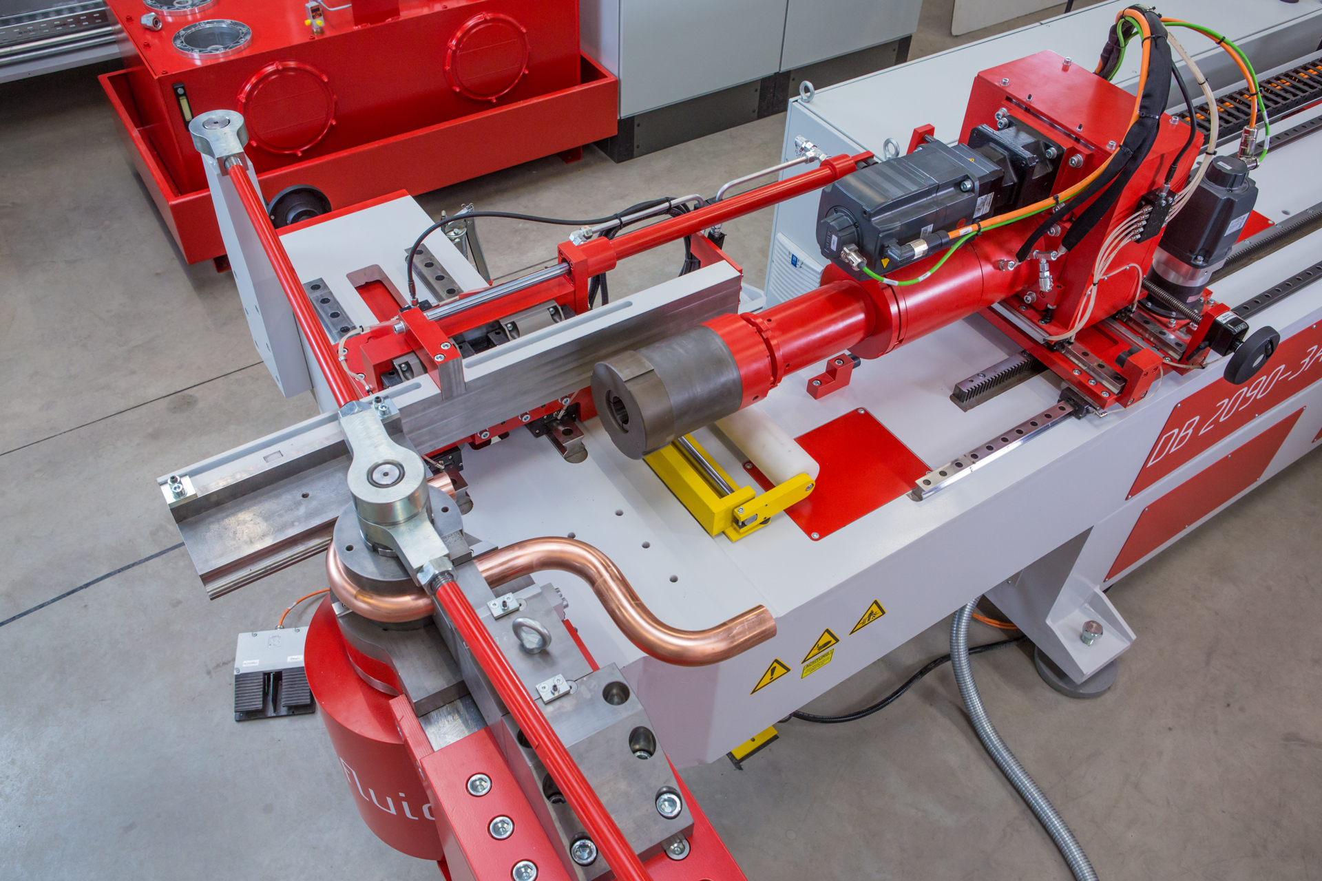 CNC-Dornbiegemaschine t bend POWERLINE 90 von transfluid beim präzisen Biegen eines Metallrohrs mit Dorntechnik in einer industriellen Rohrbearbeitungsanlage.