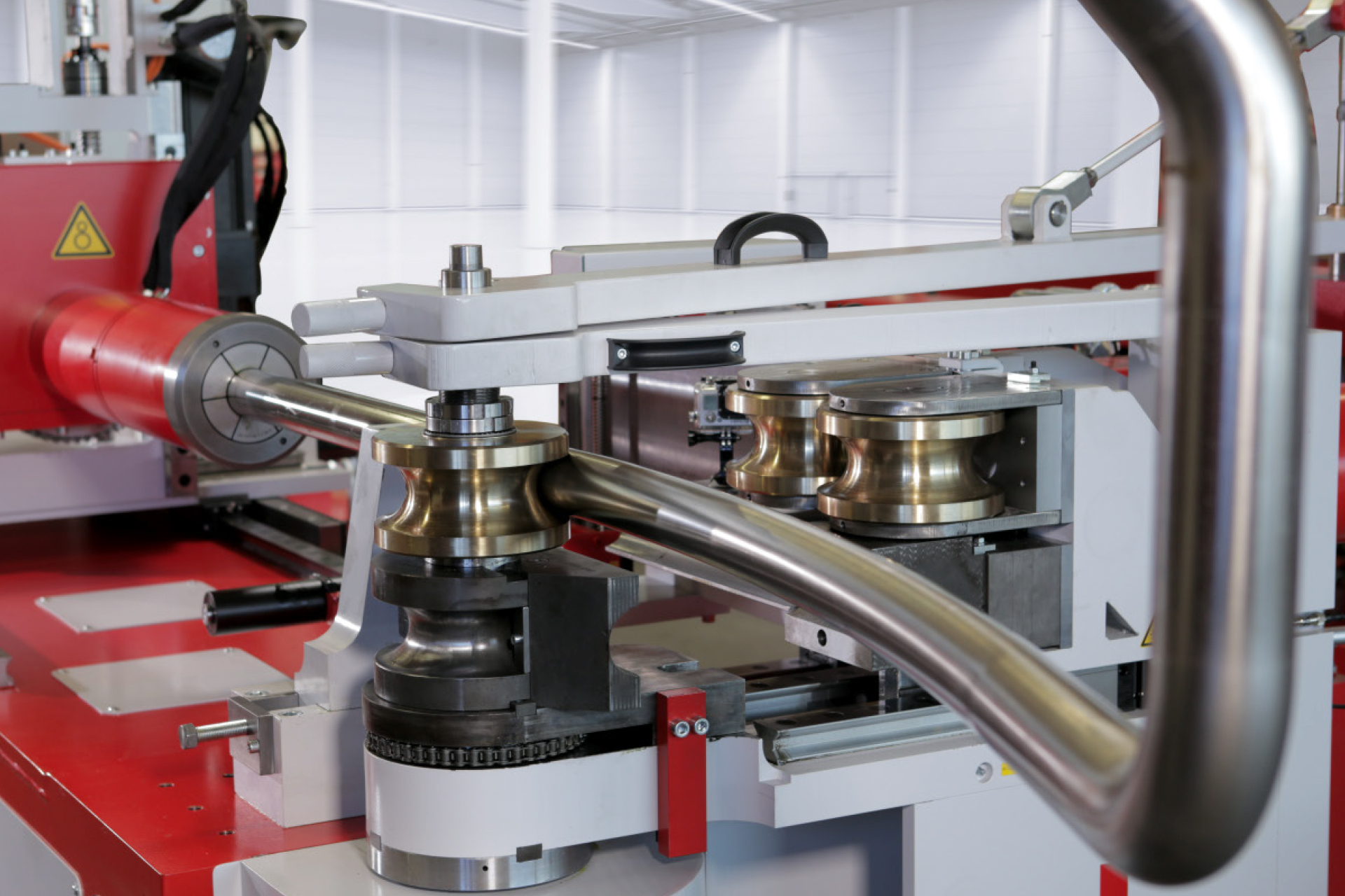 CNC-Rohrbiegemaschine der transfluid t bend PROLINE Serie beim Push-Bending, bei dem ein Metallrohr mithilfe von Biegerollen präzise in Form gebracht wird.