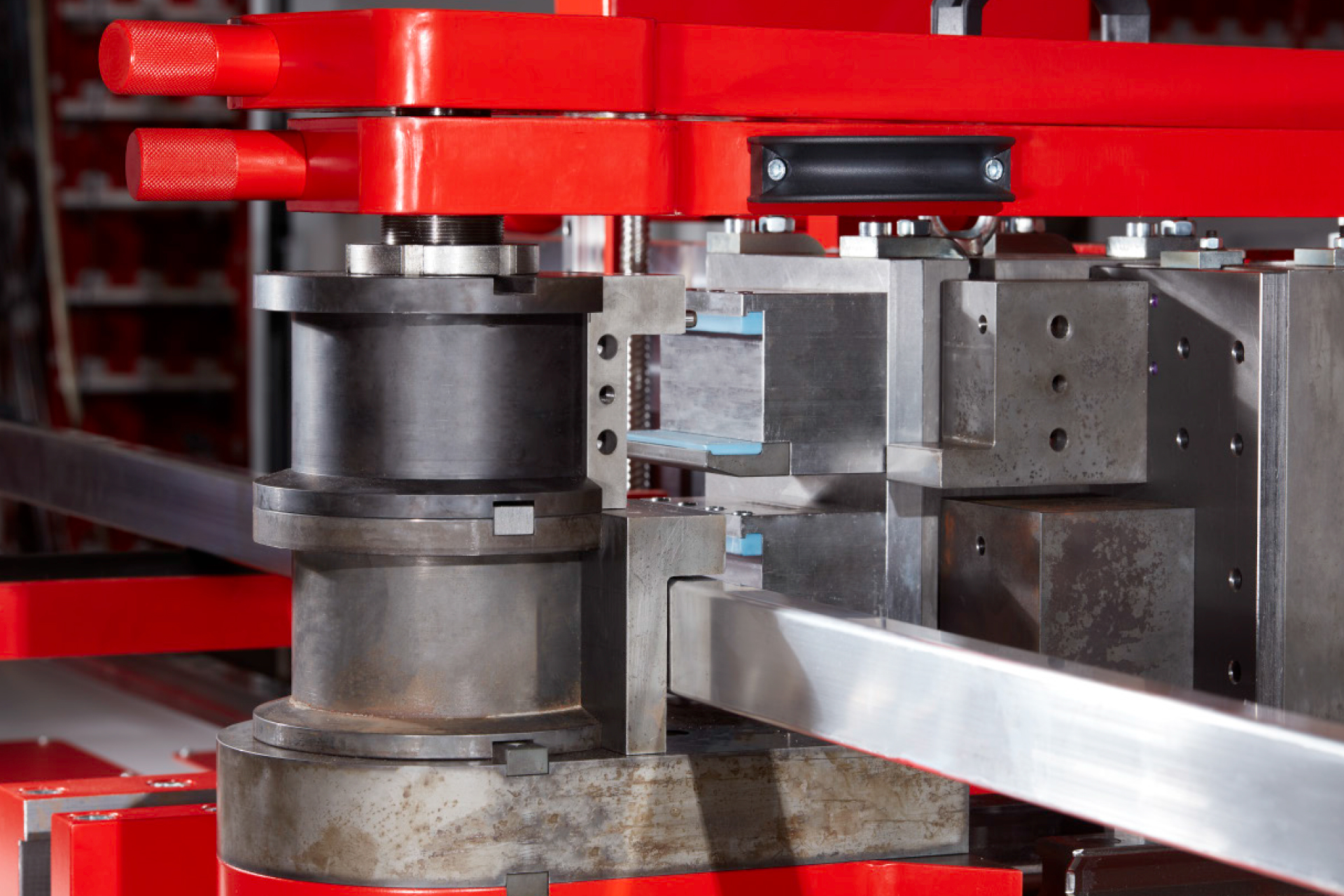 Detailaufnahme einer transfluid t bend PROLINE Rohrbiegemaschine beim Biegen eines massiven Metallprofils mit präzisen Biegewerkzeugen.