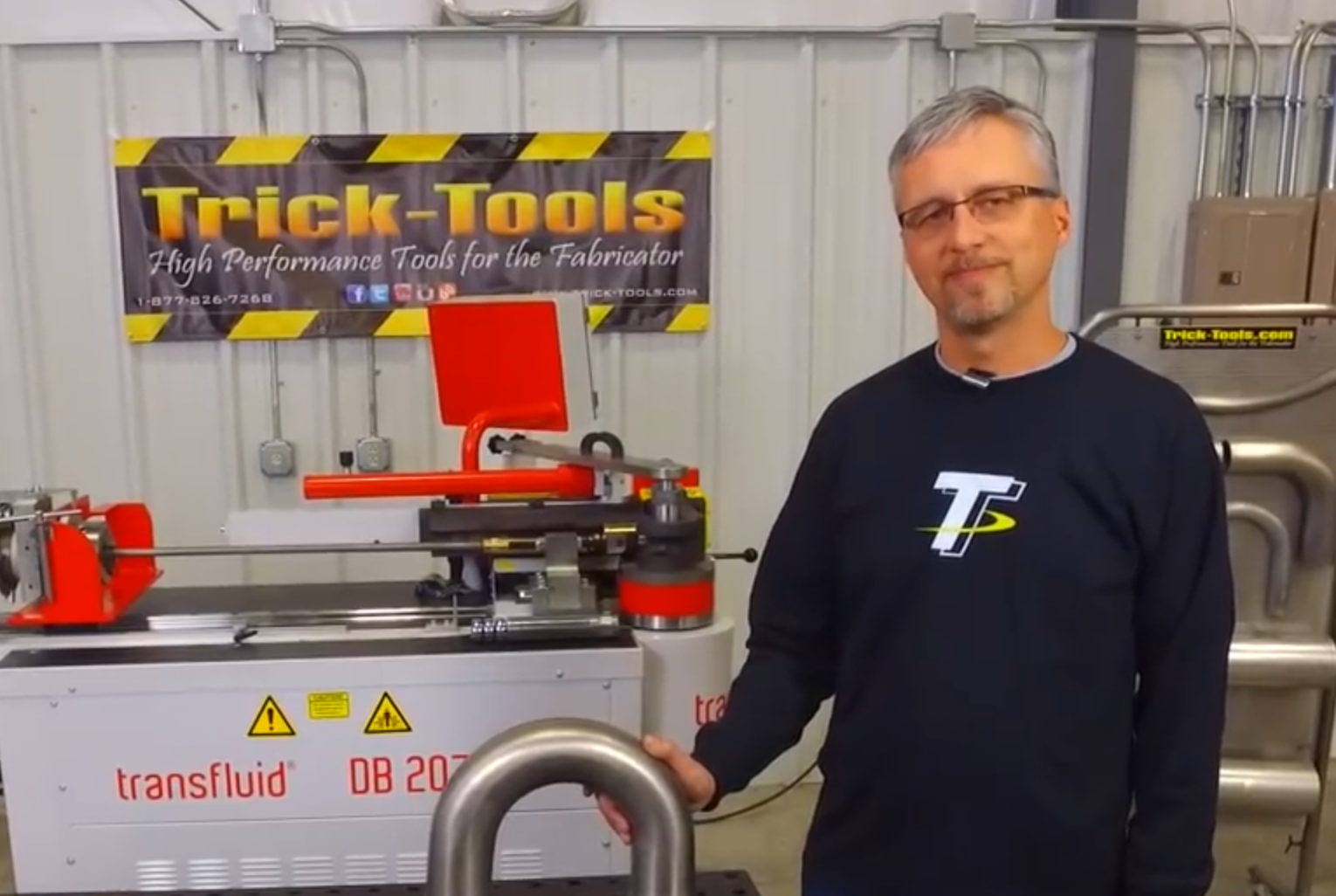 Anwender demonstriert Rohrbiegen mit transfluid Maschine und Trick-Tools in Werkstatt.