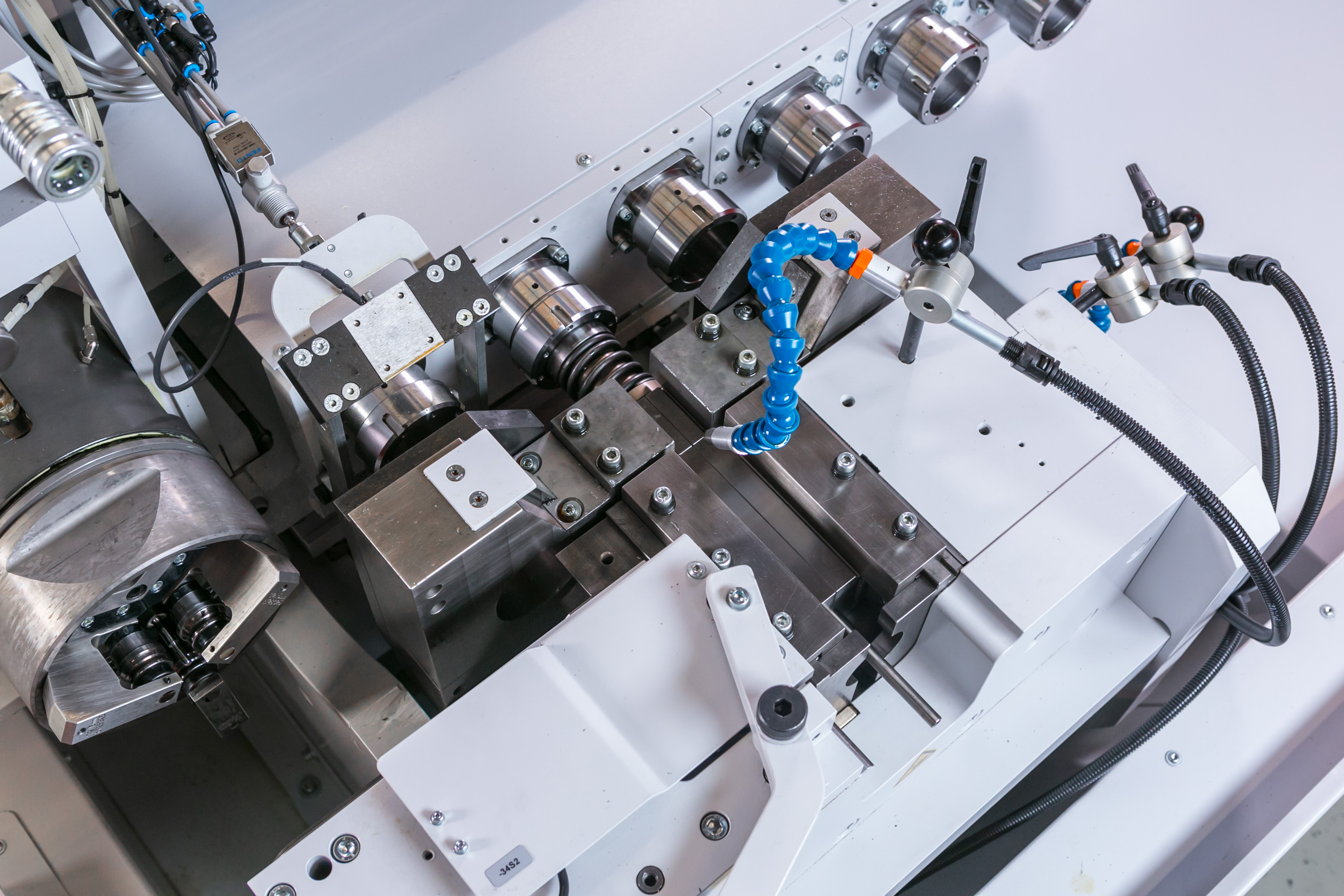 Detailansicht einer CNC-Rohrumformmaschine mit Werkzeugstationen zur präzisen Rohrendenbearbeitung.