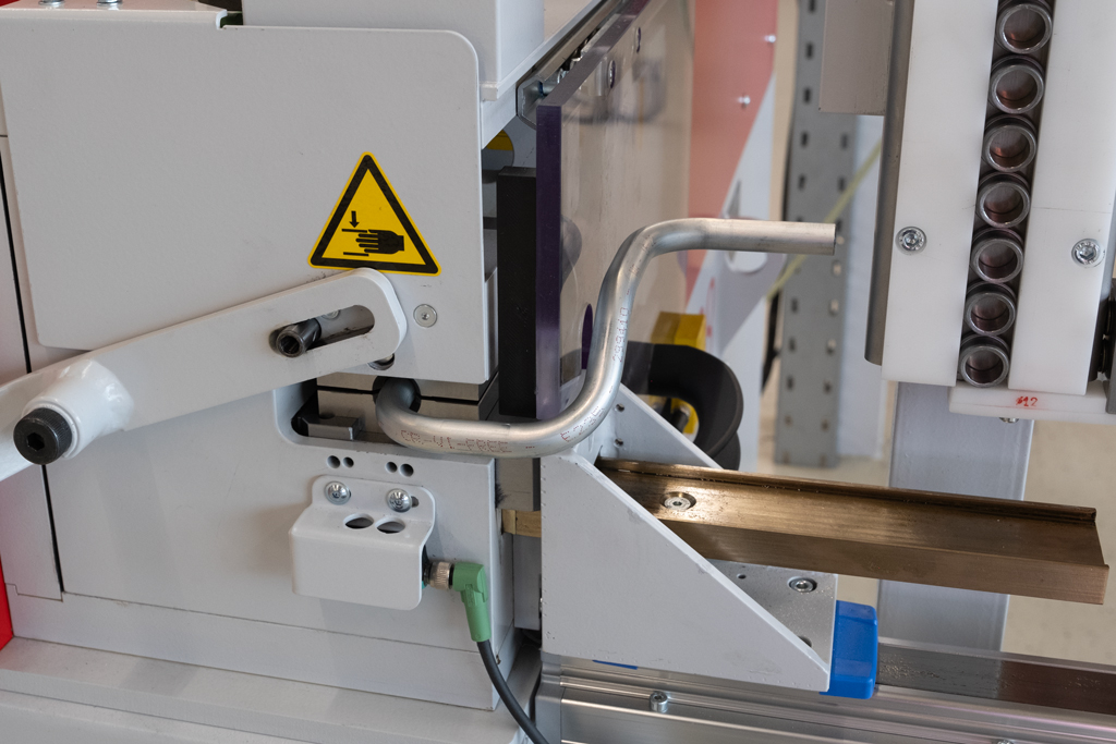 t form FLARELINE 28 Rohrumformmaschine formt gebogenes Metallrohr im geschützten Arbeitsbereich.